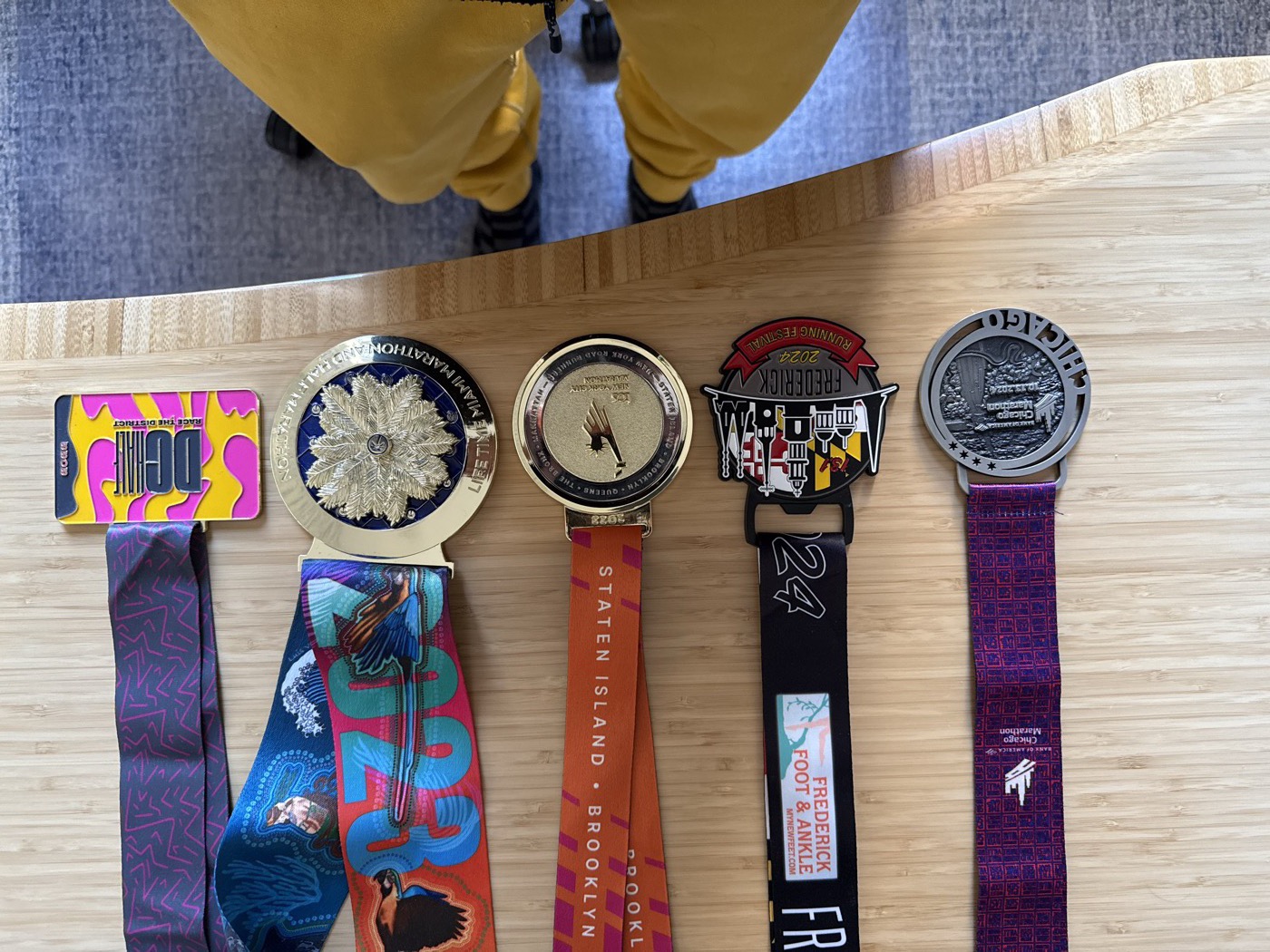 All race medals laid out — Chicago, Frederick, NYC, Miami, DC